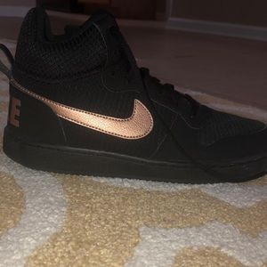 Black nike shoes,with a rose gold Nike check.